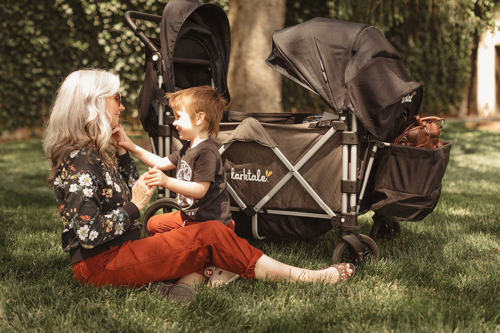mother sits with her child with the larktale caravan stroller wagon
