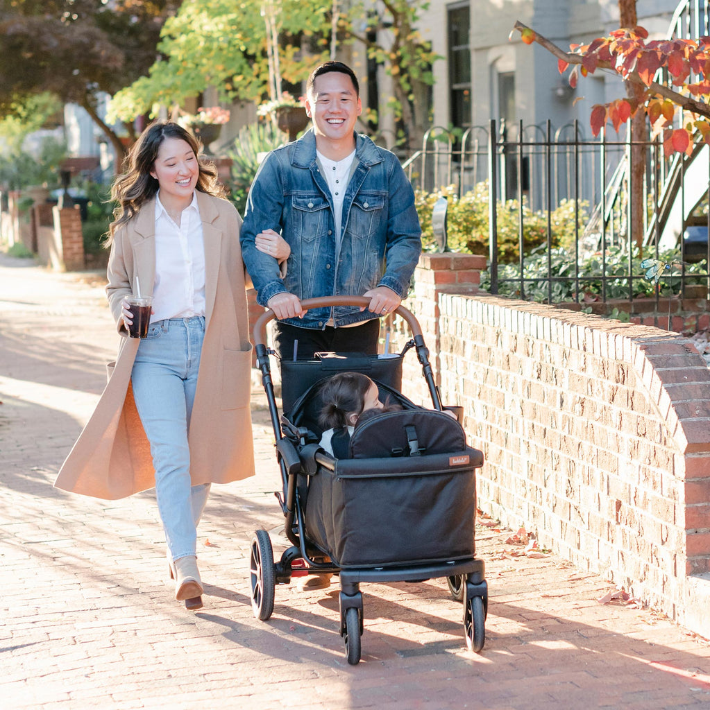 family walks on sidewalk with the sprout strollerwagon in black