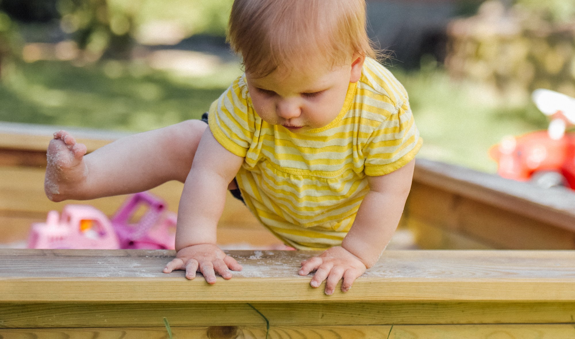 baby plays in sandbox during staycation
