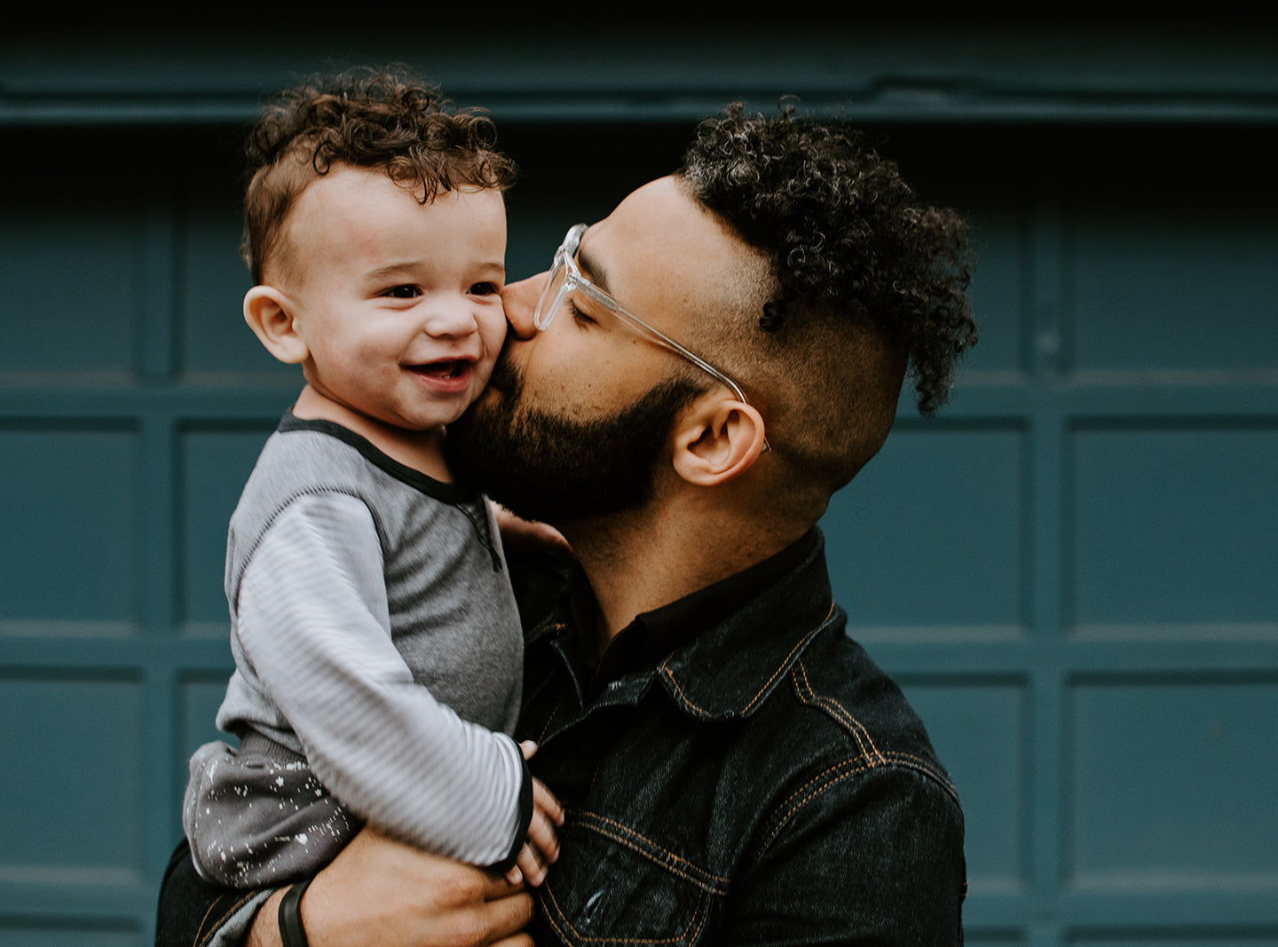 father kisses toddler on the cheek
