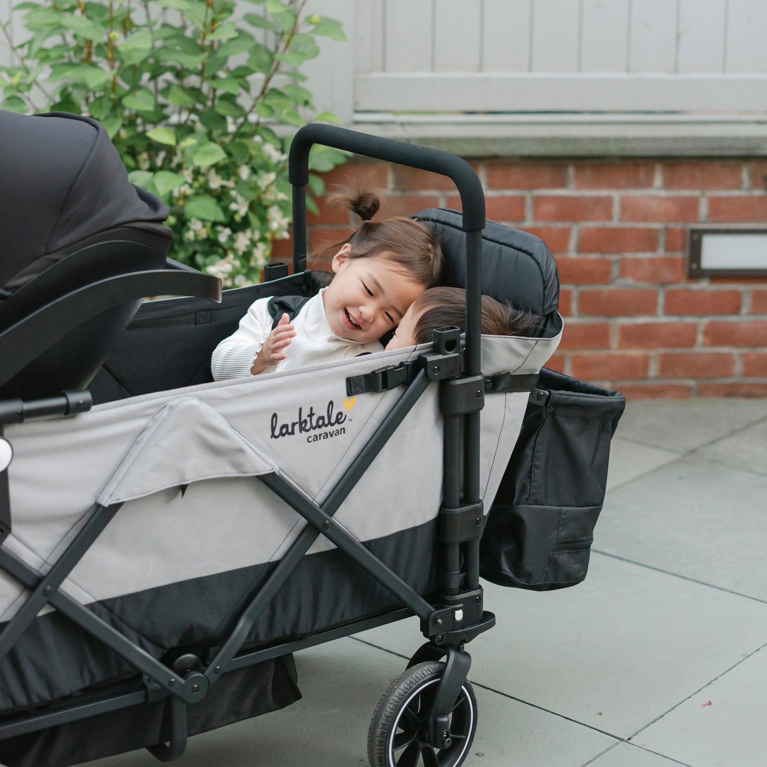 children using the caravan double seat kit with the infant car seat attached to the wagon