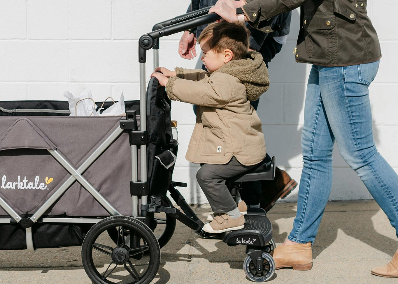kid using the stroller board connected to the caravan