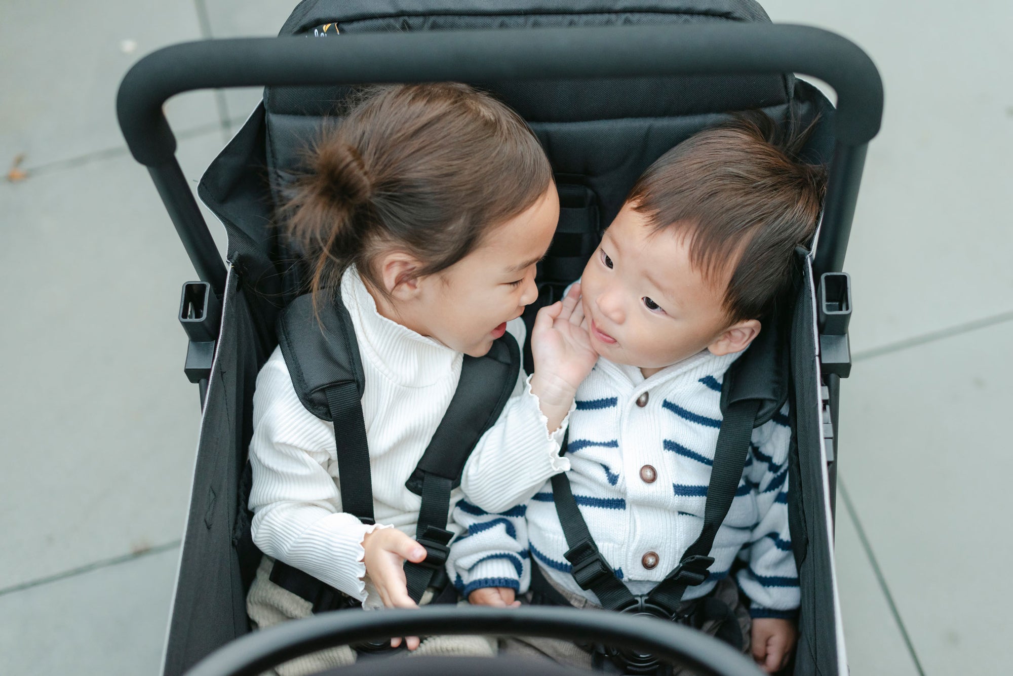 children sitting side-by-side in the caravan stroller wagon