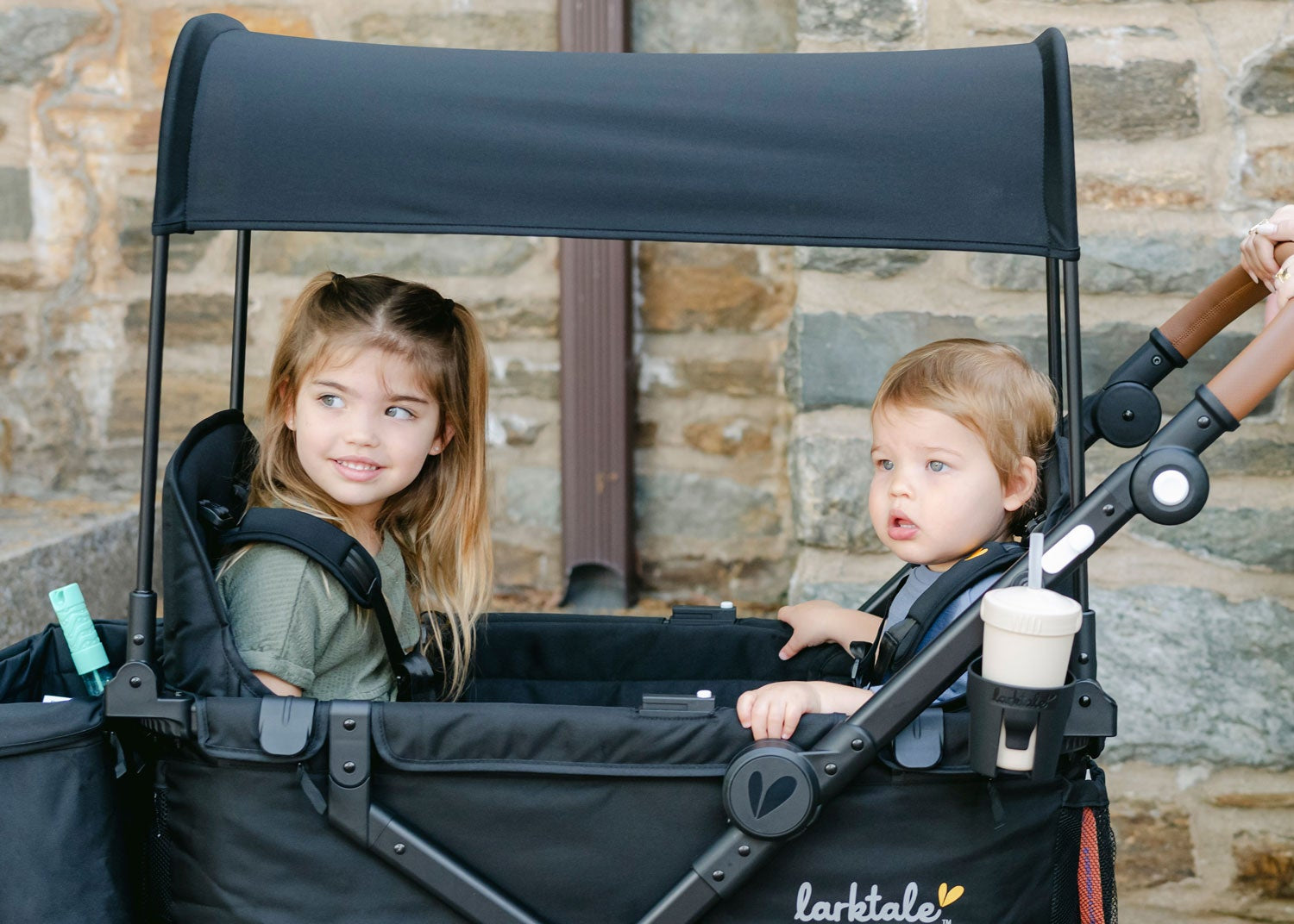 two kids sitting in the caravan coupe LTE with sun topper