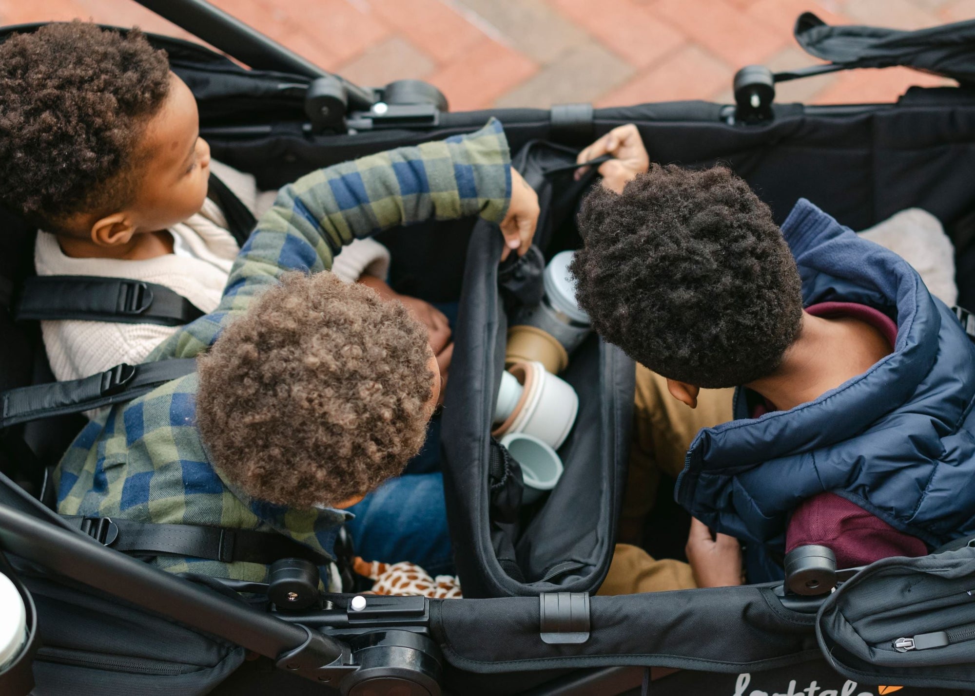 Children playing inside a stroller with a focus on their activities.