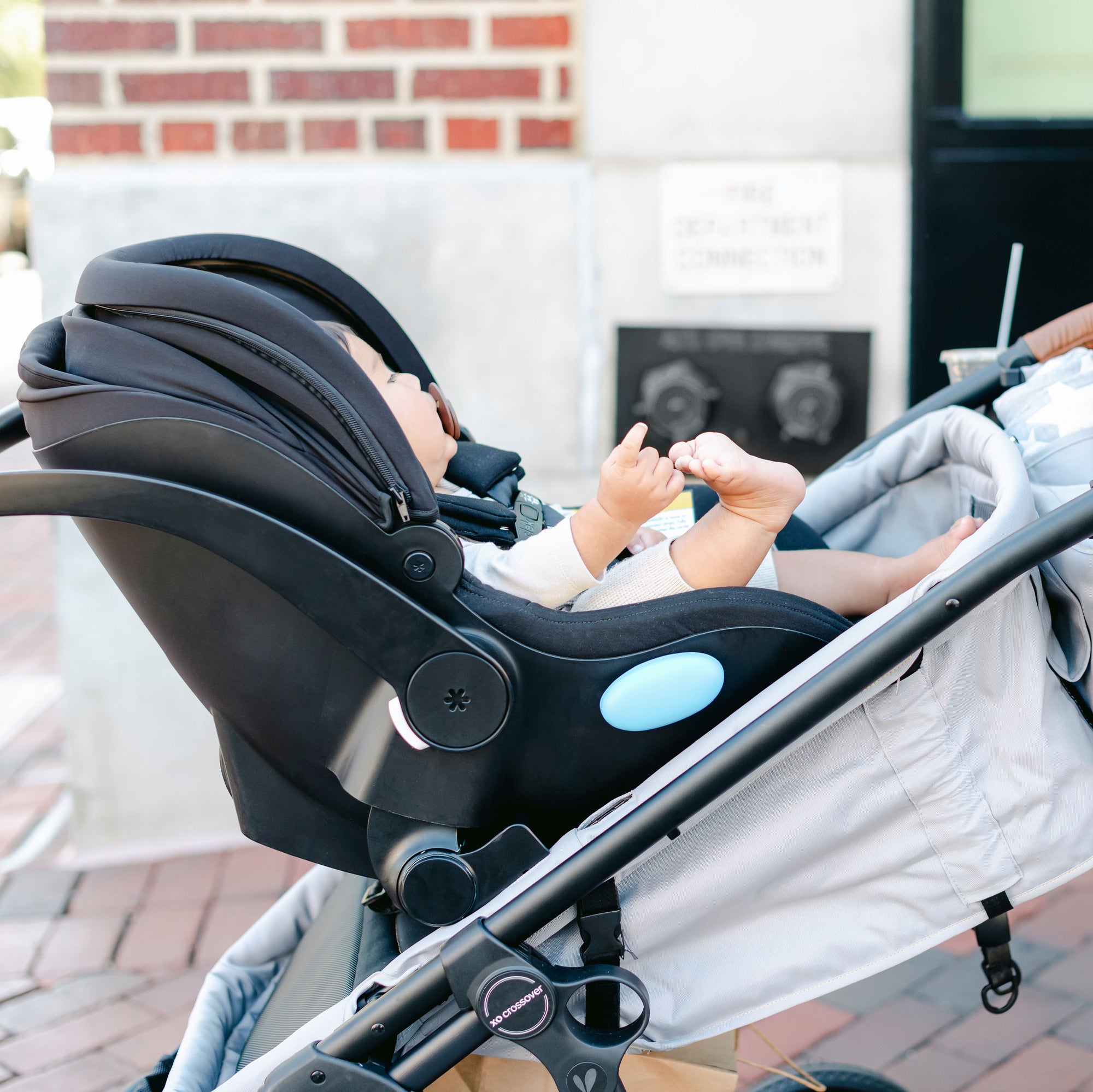 baby in car seat attached to crossover stroller/wagon