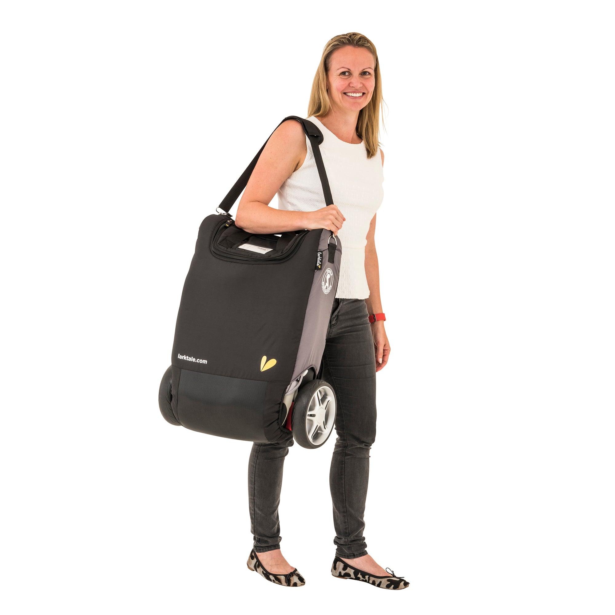 woman carries the chit chat stroller in a travel bag over her shoulder